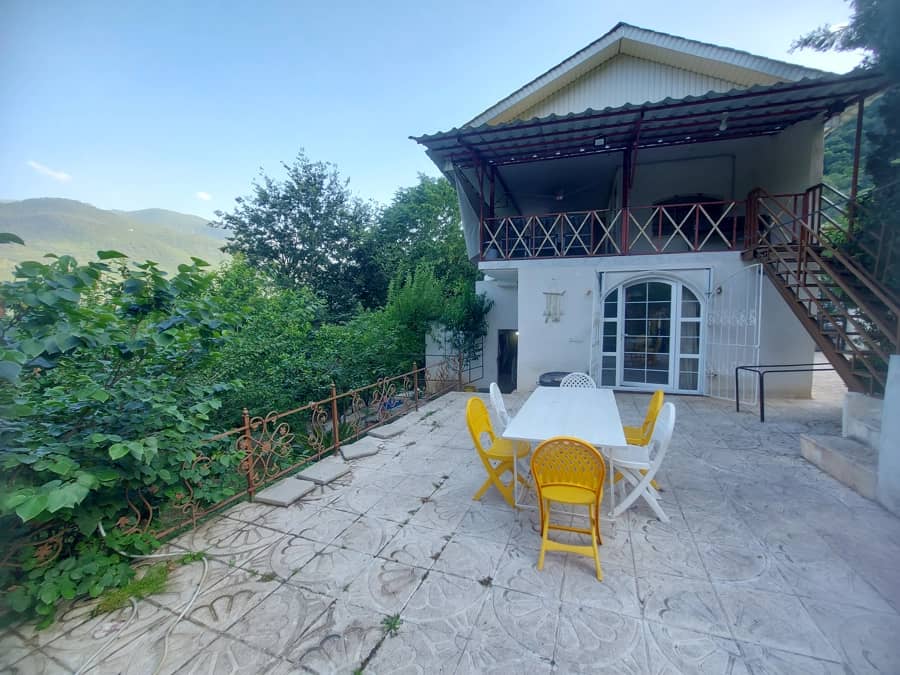 ویلا با ویوو جنگل در روستای کوهستانی وسی سر فاضلآباد تراس با میز آتشدان و منظره کوهستان و جنگل
